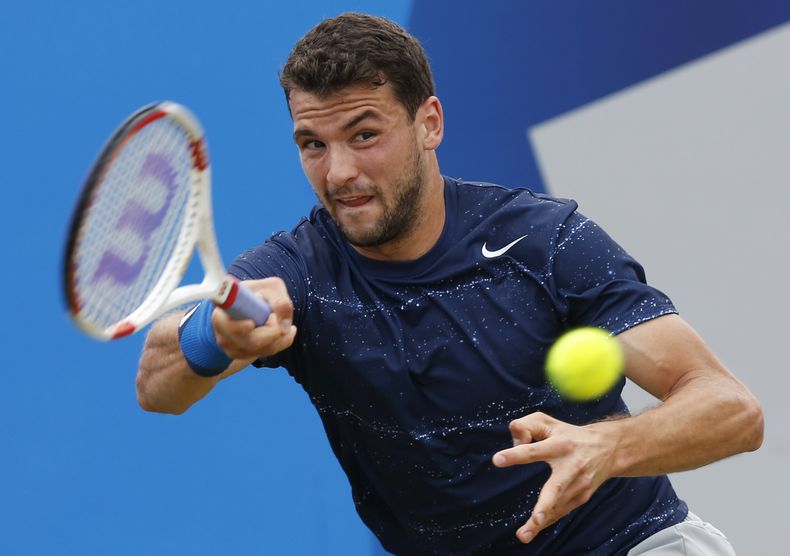 Grigor Dimitrov en un pasaje del partido en que venci&oacute; a Stan Wawrinka  en el torneo de Londres el 14 de junio del 2014. (AP Foto/Sang Tan)