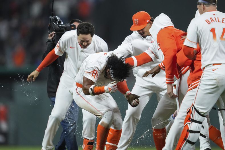 El venezolano Luis Matos (2do de izquierda a derecha) es felicitado por sus compañeros tras producir la carrera del triunfo de los Gigantes de San Francisco sobre los Filis de Filadelfia, el martes 28 de mayo de 2024 (AP Foto/Godofredo A. Vásquez)