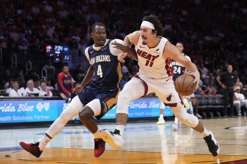 El delantero del Heat de Miami Jaime Jáquez Jr. (11) ataca la canasta ante la marca del guardia de los Pelicans de Nueva Orleans, Javonte Green (4), durante la primera mitad de un partido de pretemporada de la NBA el domingo 13 de octubre del 2024, en Miami. (AP Foto/Wilfredo Lee)