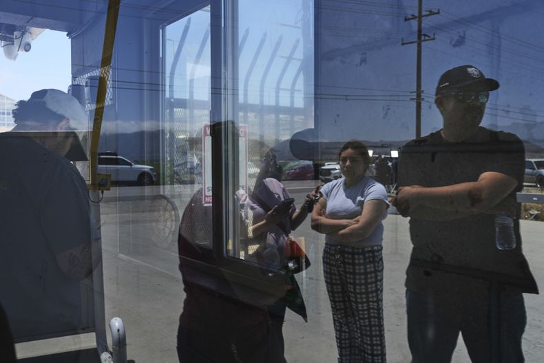 ARCHIVO - Personas esperan afuera de Glass House Farms, en Camarillo, California, un día después de una redada de inmigración en las instalaciones, el viernes 11 de julio de 2025. (AP Foto/Jae C. Hong, Archivo)