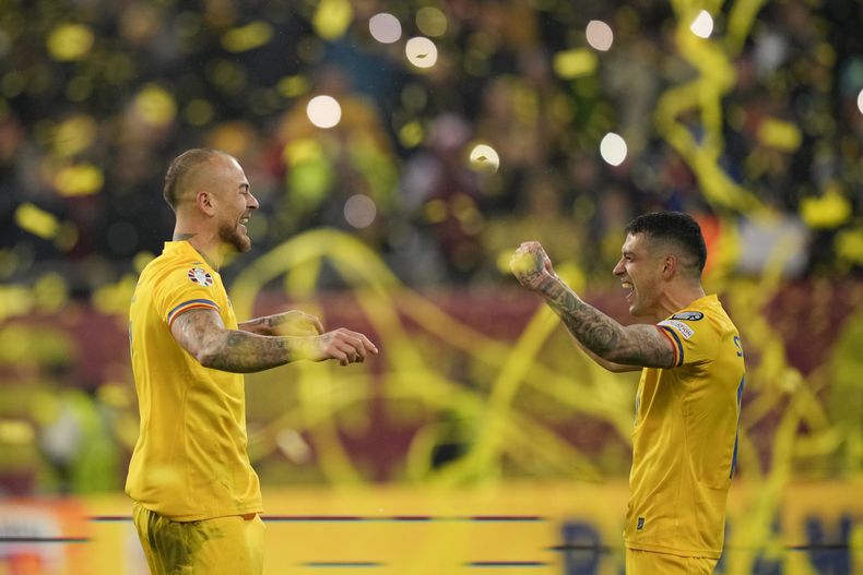 Denis Alibec y Nicolae Stanciu de Rumania celebran tras conseguir la calificación a la Euro 2024 en el Grupo I de la eliminatoria en el encuentro ante Suiza el martes 21 de noviembre del 2023. (AP Foto/Andreea Alexandru)