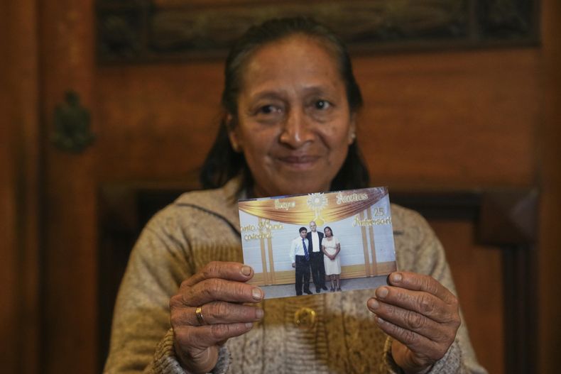 Silvia Valverde muestra una fotografía de ella y su hijo, un acólito, con el papa León XIV, entonces obispo de Chiclayo, después de la misa en la Catedral de Santa María en Chiclayo, Perú, el jueves 8 de mayo de 2025. (AP Foto/Guadalupe Pardo)