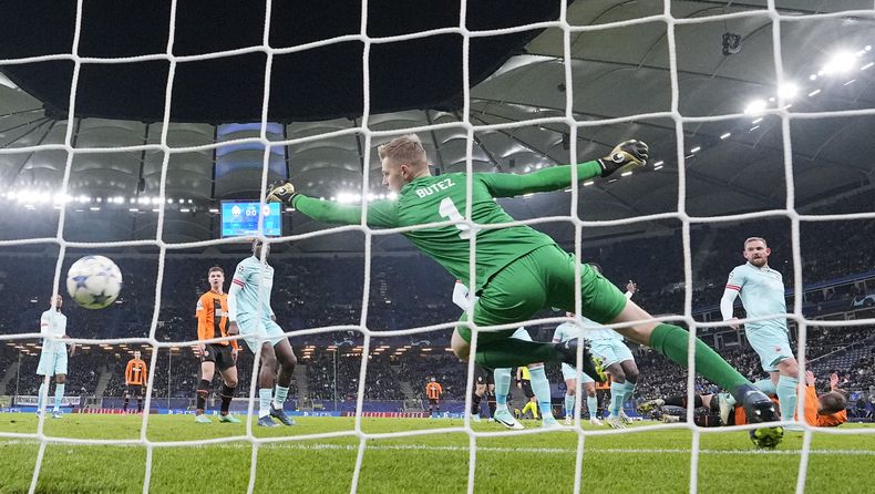 Mykola Matviyenko (derecha) remata de cabeza para anotar el primer gol de Shakhtar Donestk, batiendo al arquero Jean Butez, en el partido de la Liga de Campeones, el martes 28 de noviembre de 2023, en Hamburgo. (AP Foto/Martin Meissner)