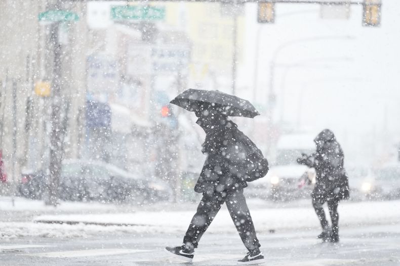 Unas personas caminan durante una tormenta invernal en Filadelfia, el 13 de febrero de 2024. (AP Foto/Matt Rourke)