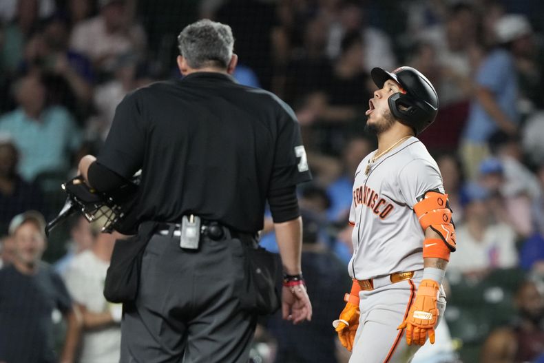 Thairo Estrada, de los Gigantes de San Francisco, a la derecha, celebra después de su jonrón de tres carreras mientras el umpire Manny González, a la izquierda, observa durante la novena entrada contra los Cachorros de Chicago, el lunes 17 de junio de 2024, en Chicago. (AP Foto/Charles Rex Arbogast)