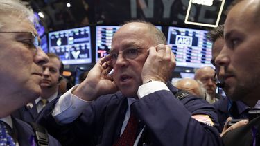 americateve | En esta fotograf&iacute;a de archivo del 13 de noviembre de 2013, el corredor Frederick Reimer, al centro, utiliza su tel&eacute;fono celular mientras trabaja en el piso de la Bolsa de Valores de Nueva York. El &iacute;ndice industrial Dow Jones rebas&oac