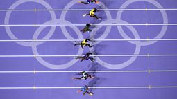 Noah Lyles (tercero desde abajo) corre rumbo a la victoria en la final de los 100 metros masculinos en los Juegos Olímpicos de París, el domingo 4 de agosto de 2024, en Saint-Denis, Francia. (AP Foto/David J. Phillip)