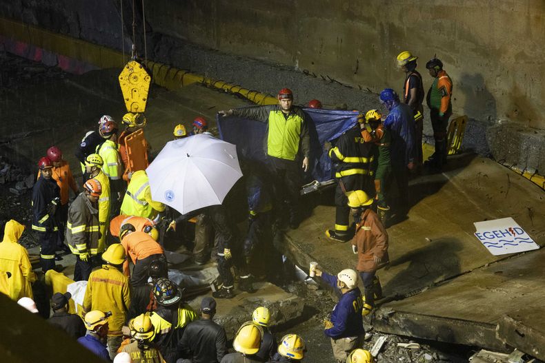 Equipos de rescate trabajan en el lugar donde se derrumbó un muro en la entrada de un túnel en Santo Domingo, República Dominicana, el sábado 18 de noviembre de 2023. Según la Defensa Civil, al menos 9 personas murieron cuando el muro se derrumbó debido a las fuertes lluvias. (Foto AP/Eddy Vittini)
