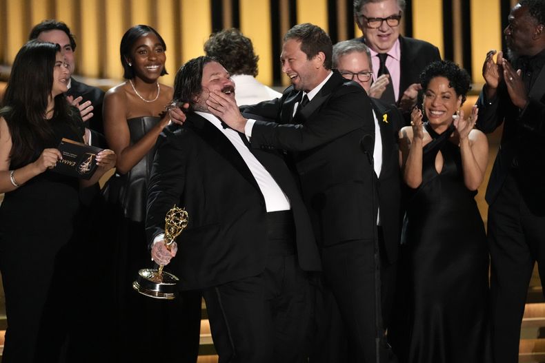 Matty Matheson, centro, y Ebon Moss-Bachrach se besan después de que The Bear ganara el premio a mejor comedia en la 75a edición de los Premios Emmy el lunes 15 de enero de 2024 en el Teatro Peacock de Los Ángeles. (Foto AP/Chris Pizzello)