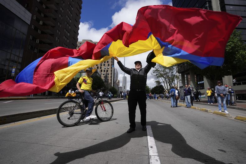Un manifestante ondea una bandera nacional en una marcha contra el gobierno del presidente colombiano, Gustavo Petro, en la plaza de Bolívar en Bogotá, Colombia, el martes 20 de junio de 2023. La oposición en Colombia está manifestándose para pedir la retirada de las reformas en el sistema de salud, de pensiones y laborales. (AP Foto/Fernando Vergara)