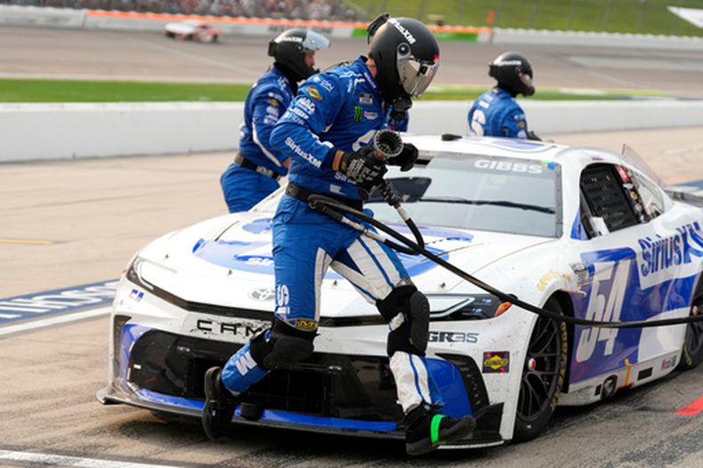 Un miembro del equipo salta frente al auto de Ty Gibbs durante una parada en fosos en una carrera de la Nysted NASCAR Cup Series, el domingo 9 de agosto de 2026, en Iowa Speedway en Newton, Iowa. (Foto AP/Charlie Neibergall)