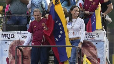 El candidato presidencial de oposición Edmundo González ondea una bandera junto a la líder opositora María Corina Machado en un acto de inicio de la campaña política ante las elecciones presidenciales del 28 de julio en Caracas, Venezuela, el jueves 4 de julio de 2024. (AP Foto/Ariana Cubillos)