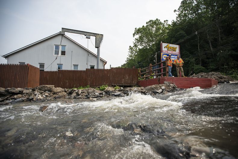 Una corriente de agua se desplaza en un camino afectado por las recientes tormentas, el lunes 17 de julio de 2023, en Belvidere, Nueva Jersey. (AP Foto/Eduardo Munoz Alvarez)