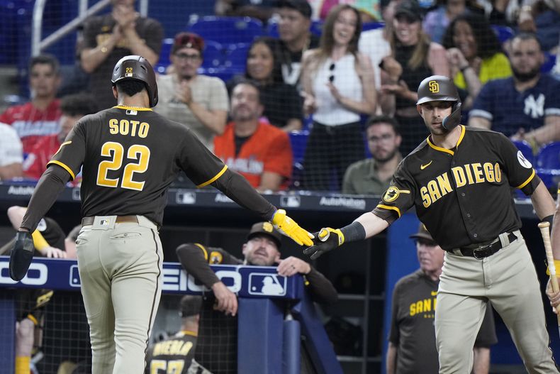 El dominicano Juan Soto, de los Padres de San Diego, es felicitado por su compañero Austin Nola, tras anotar ante los Marlins de Miami el martes 30 de mayo de 2023 (AP Foto/Wilfredo Lee)
