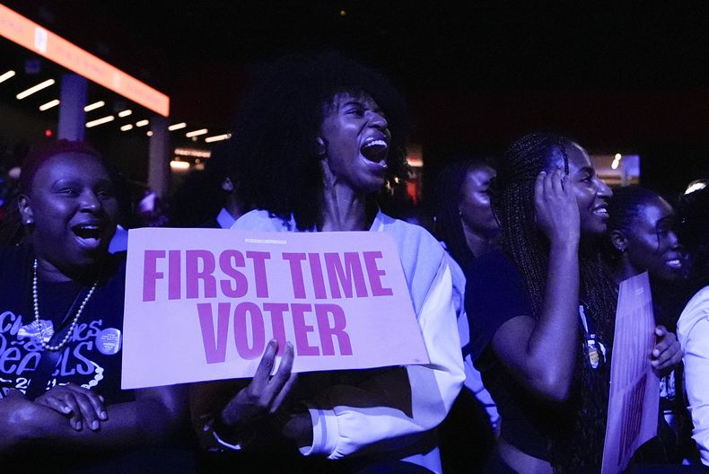 Una mujer que vota por primera vez anima a la ex primera dama Michelle Obama mientras da un discurso, el martes 29 de octubre de 2024, en College Park, Georgia. (AP Foto/Brynn Anderson)