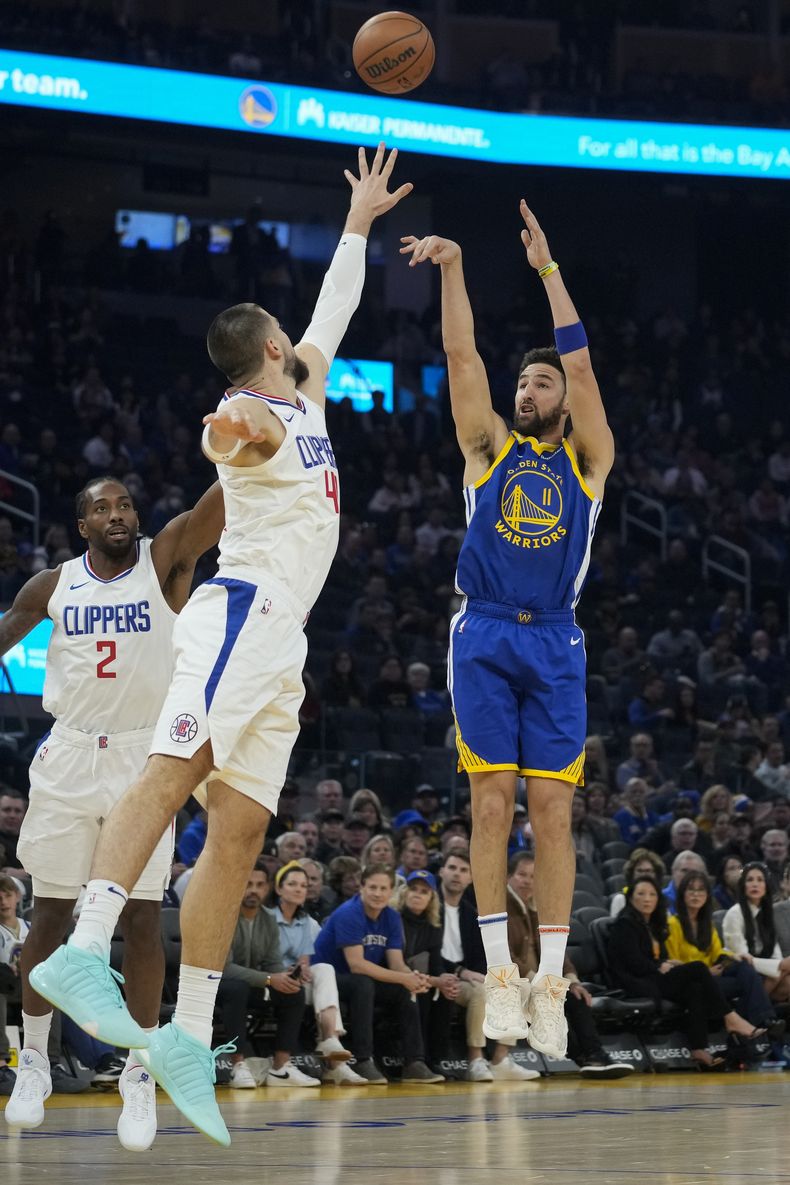 El base de los Warriors de Golden State Klay Thompson lanza un tiro de tres sobre el pívot de los Clippers de Los Ángeles Ivica Zubac en el encuentro del jueves 30 de noviembre del 2023. (AP Foto/Godofredo A. Vásquez)