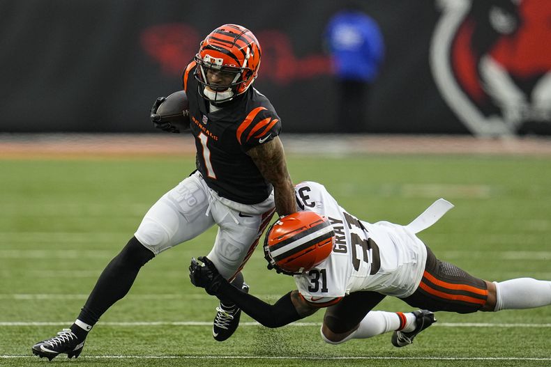 El receptor de los Bengals de Cincinnati JaMarr Chase tacleado pr el safety de los Browns de Cleveland Vincent Gray mientras corre con el balón tras una atrapada en el encuentro del domingo 7 de enero del 2024. (AP Foto/Sue Ogrocki)