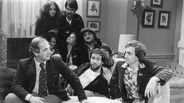 ARCHIVO - El secretario de prensa de la Casa Blanca, Ron Nessen, a la izquierda, aparece en el set de Saturday Night Live con el productor Lorne Michaels, a la derecha, y los miembros del elenco Chevy Chase, en primer plano al centro, Laraine Newman, al fondo a la izquierda, Dan Aykroyd, al fondo a la derecha, Jane Curtain, segunda fila de izquierda a derecha, Gilda Radner, John Belushi y Garret Morris, parcialmente visible, en abril (Foto AP)