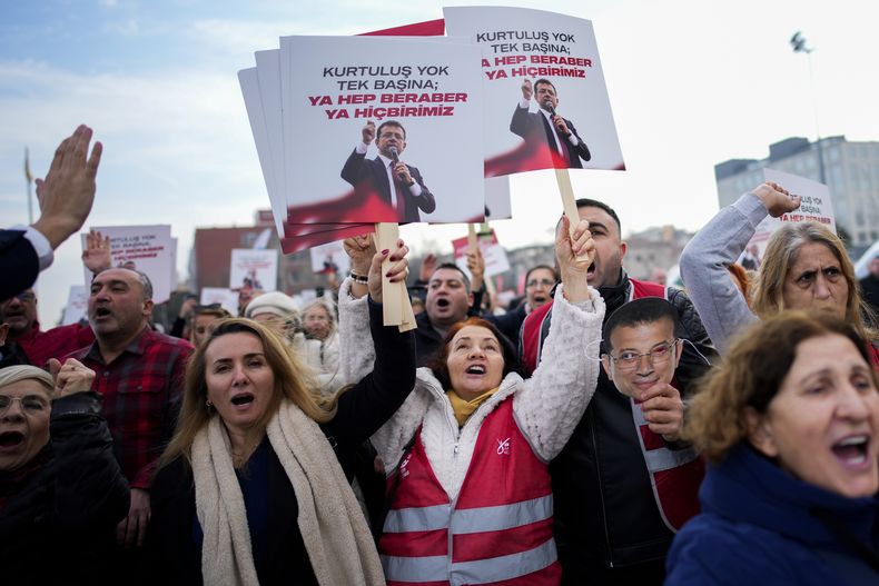 Seguidores del alcalde de Estambul, Ekrem Imamoglu, corean consignas frente a un tribunal de la ciudad, en Turquía, el 31 de enero de 2025. Los carteles, en turco, dicen: No hay salvación por separado, o todos o ninguno. (AP Foto/Emrah Gurel)