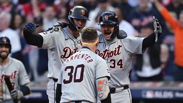 Trey Sweeney (27) y Jake Rogers, de los Tigres de Detroit, esperan en el plato a su compañero de equipo Kerry Carpenter (30) después de que Carpenter conectó un jonrón de tres carreras en la novena entrada durante el Juego 2 de la Serie Divisional de la Liga Americana de béisbol contra los Guardianes de Cleveland, el lunes 7 de octubre de 2024, en Cleveland. (AP Foto/David Dermer)