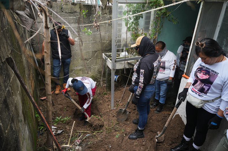 ARCHIVO - Familiares de personas desaparecidas, miembros de un grupo llamado Guerreros Buscadores, inspeccionan un área donde sospechan que podrían estar enterrados cuerpos, en el barrio Valle de los Olivos de Guadalajara, México, el 14 de octubre de 2025. (Foto AP/Eduardo Verdugo, Archivo)