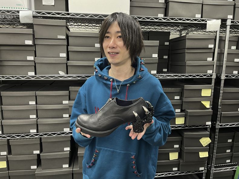 Ryosuke Matsui, el diseñador japonés de los zapatos de Godzilla que usó el equipo de la película galardonada con el premio a los mejores efectos visuales Godzilla Minus One en la ceremonia de los Oscar, sostiene uno de sus diseños durante una entrevista con The Associated Press en las oficinas de su empresa ea las afueras de Tokio el viernes 22 de marzo de 2024. (Foto AP/Yuri Kageyama)