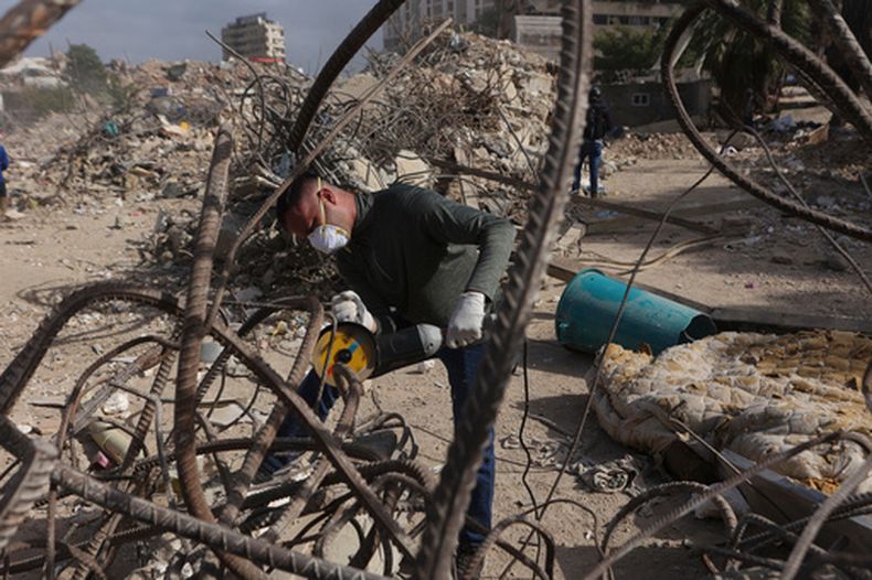 ARCHIVO - Un trabajador corta hierros entre los escombros de un edificio de viviendas construido dentro de un programa del gobierno, y que se derrumbó durante dos terremotos gemelos en La Guaira, Venezuela, el 25 de julio de 2026. (AP Foto/Pedro Mattey, Archivo)