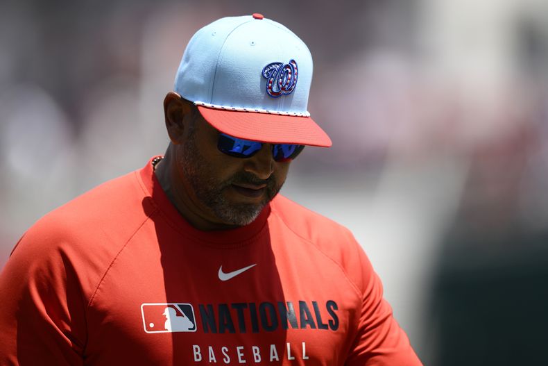 El mánager de los Nacionales de Washington, Dave Martínez, usa una gorra con temática patriótica mientras camina de regreso a la cueva después de un cambio de lanzador durante la quinta entrada de un partido de béisbol contra los Medias Rojas de Boston, el viernes 4 de julio de 2025, en Washington. (Foto AP/Nick Wass)
