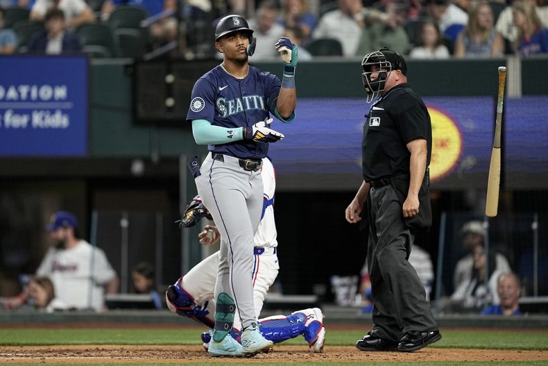 El dominicano Julio Rodríguez, de los Marineros de Seattle, lanza su bate tras recibir un boleto en el encuentro del martes 23 de abril de 2024, ante los Rangers de Texas (AP Foto/Tony Gutiérrez)