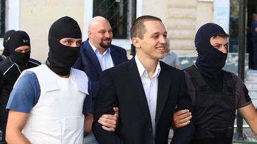 americateve | Ilias Kasidiaris (centro), legislador del partido griego Amanecer Dorado, de extrema derecha, es escoltado por dos agentes antiterroristas hacia un tribunal para una audiencia preliminar sobre los cargos de participar en una organizaci&oacute;n criminal,