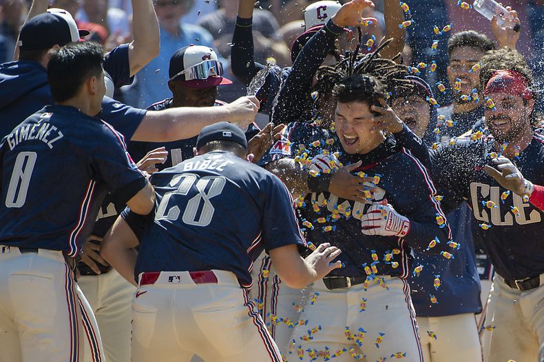 Andrés Giménez, Tanner Bibee y sus compañeros de equipo de los Guardianes de Cleveland felicitan a Will Brennan, centro, después de conectar un jonrón de tres carreras ante el lanzador relevista de los Mellizos de Minnesota, Jhoan Durán, al final de un juego de béisbol en Cleveland, el domingo 19 de mayo de 2024. (AP Foto/Phil Long)