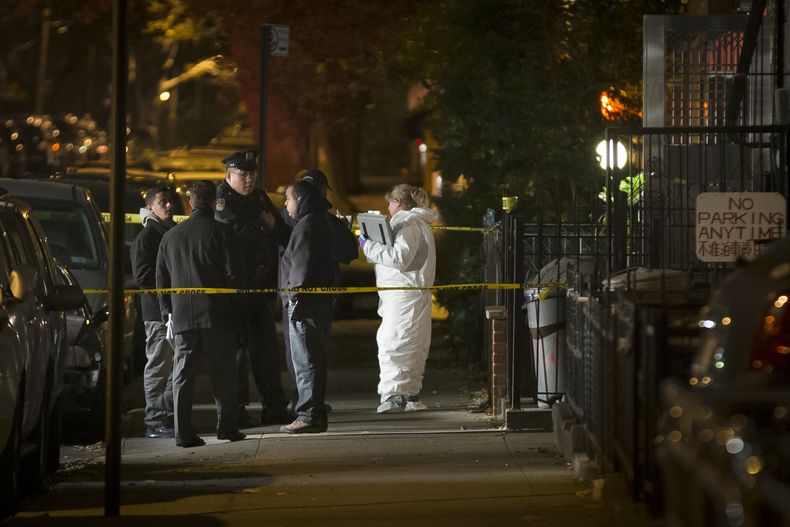 Varios polic&iacute;as aguardan frente a una residencia del distrito de Brooklyn, en Nueva York, el domingo 27 de octubre del 2013. Cinco personas, entre ellas un ni&ntilde;o de corta edad, fueron muertas a pu&ntilde;aladas en esa residencia antes del ama