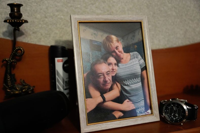 Foto familiar de Dmytro con su hija Ekaterina y su esposa Tetiana, en la vivienda de la familia, junto al reloj que el trabajador llevaba cuando fue asesinado por un ataque ruso el año pasado en la planta termoeléctrica donde laboraba, el miércoles 29 de octubre de 2025. (AP Foto/Julia Demaree Nikhinson)