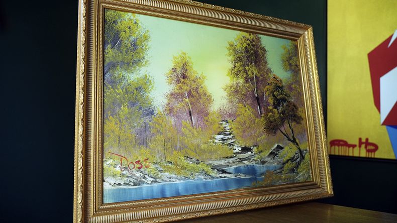 El cuadro A Walk in the Woods, la primera obra de Bob Ross pintada durante su icónico programa de televisión The Joy of Painting, es exhibida en la casa de Ryan Nelson, propietario de la galería Modern Artifact, el martes 19 de septiembre de 2023, en Wayzata, Minnesota. (AP Foto/Mark Vancleave)