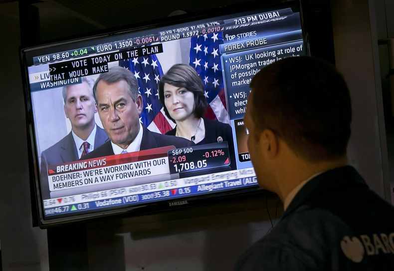 El especialista de la Bolsa de Nueva York, Frank Masiello ve una conferencia de prensa donde John Boehner, l&iacute;der de la C&aacute;mara de Representantes, informa sobre las discusiones fiscales en el Congreso, el martes 15 de octubre de 2013. (Foto AP