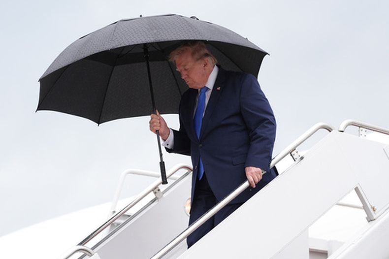 El presidente de Estados Unidos, Donald Trump, lleva un paraguas para desembarcar del Air Force One en la base conjunta Andrews, Maryland, el domingo 2 de agosto de 2026, a su regreso a Washington. (AP Foto/Jacquelyn Martin)
