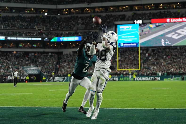CeeDee Lamb (88), receptor de los Cowboys de Dallas, atrapa un pase de anotación frente a Riq Woolen (2), cornerback de los Eagles de Filadelfia, durante la segunda mitad del juego de la NFL, el lunes 26 de octubre de 2026, en Filadelfia. (AP Foto/Matt Rourke)