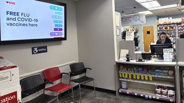 Un letrero en el que se ofrecen vacunas contra la gripe y el COVID-19 aparece en una pantalla de una farmacia, el martes 13 de febrero de 2024, en Buffalo Grove, Illinois. (AP Foto/Nam Y. Huh, archivo)