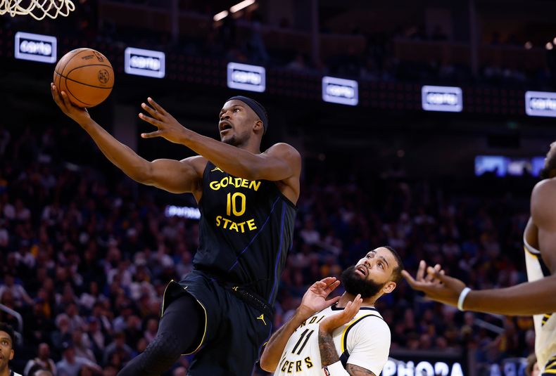 Jimmy Butler III (10), de los Warriors de Golden State, se alza para anotar frente a Cody Martin (11), de los Pacers de Indiana, durante la primera mitad del juego de baloncesto de la NBA, el domingo 9 de noviembre de 2025, en San Francisco. (AP Foto/Kelley L Cox)