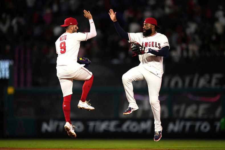 Zach Neto y Jo Adell, de los Angelinos de Los Ángeles, festejan el triunfo sobre los Rangers de Texas, el viernes 22 de mayo de 2026 (AP Foto/Mark J. Terrill)