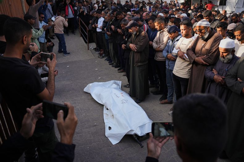 Dolientes rezan junto al cuerpo de Ruba Abu Al-Ola, de 22 años, que murió en un ataque del ejército israelí, durante su funeral en el hospital Nasser, en Jan Yunis, Gaza, el 20 de noviembre de 2025. (AP Foto/Abdel Kareem Hana)