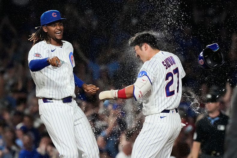 El japonés Seiya Suzuki, derecha, de los Cachorros de Chicago, celebra con un compañero despúes de batear un sencillo productor de la carrera de la victoria para dejar tendidos a los Padres de San Diego en la novena entrada del juego de béisbol de Grandes Ligas, el lunes 29 de junio de 2026, en Chicago. (AP Foto/Nam Y. Huh)