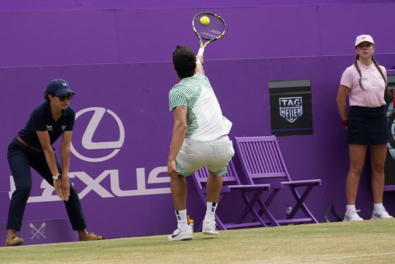 Carlos Alcaraz, de España, devuelve una pelota a Sebastian Korda, de Estados Unidos, durante su partido de semifinales en el torneo Queens Club de tenis, en Londres, el sábado 24 de junio de 2023. (AP Foto/Alberto Pezzali)