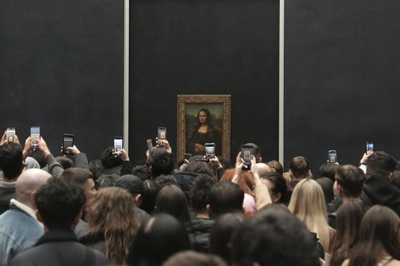 Visitantes toman fotografías desde su teléfono móvil de Leonardo da Vinci (AP Photo/Thibault Camus)