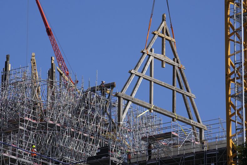 Una grúa levanta un enorme marco de roble en la catedral de Notre Dame de París, el martes 11 de julio de 2023 en París. Los paneles se volverán a montar en la parte superior de Notre Dame para reemplazar el techo que las llamas convirtieron en cenizas en 2019. (Foto AP/Christophe Ena)