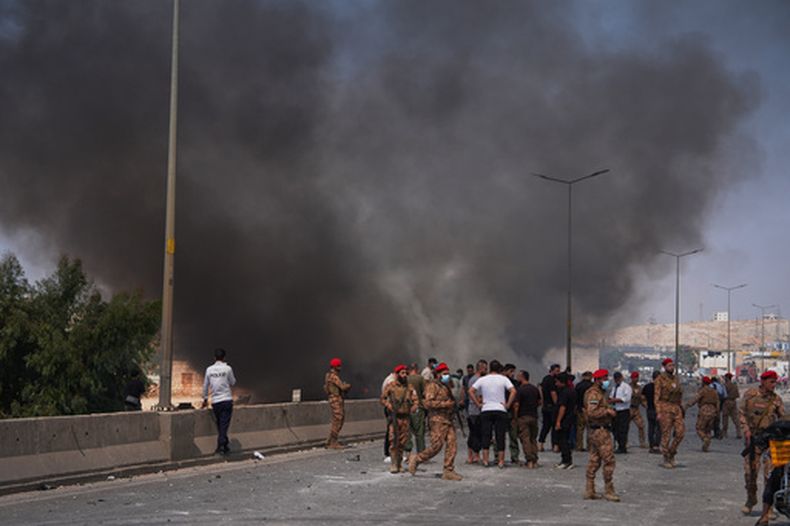 Efectivos de las fuerzas de seguridad sirias y otros se acercan mientras una columna de humo señala el lugar donde se produjo una explosión, en lo que según la prensa estatal era un depósito de armas en Burj al-Nimra, cerca de Sarmada, en la provincia de Idlib, Siria, el 9 de septiembre de 2026.(AP Foto/Omar Albam)