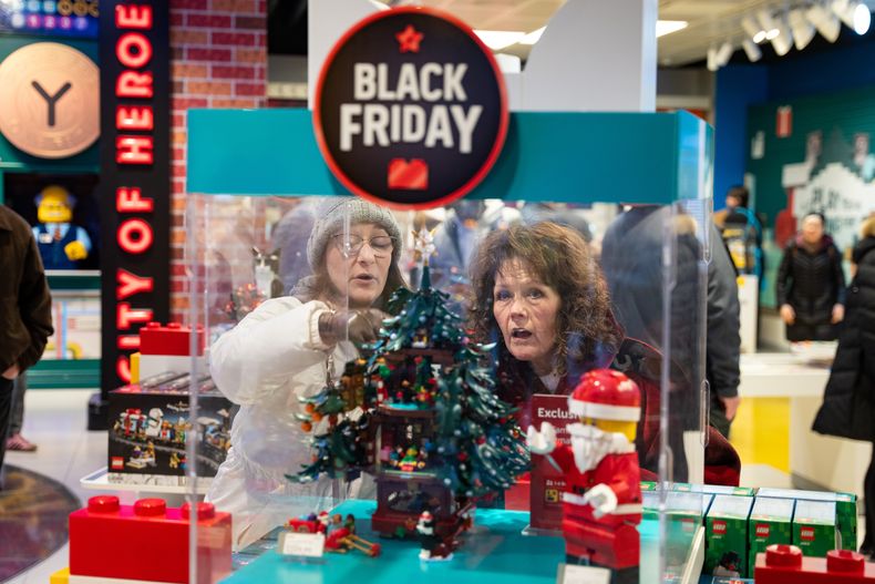Compradores del Black Friday admiran un juego navideño de LEGO en la tienda insignia de la marca en Nueva York, el viernes 28 de noviembre de 2025. (AP Foto/Angelina Katsanis)