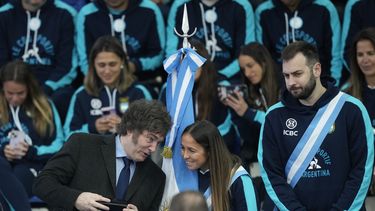 El presidente argentino Javier Mieli, a la izquierda, habla con la jugadora de hockey sobre césped Rocío Sánchez Moccia y el jugador de vóleibol Luciano De Cecco durante la ceremonia de despedida de los atletas argentinos que competirán en los Juegos Olímpicos de París, en Buenos Aires, Argentina, viernes 5 de julio, 2024. (AP Foto/Natacha Pisarenko)