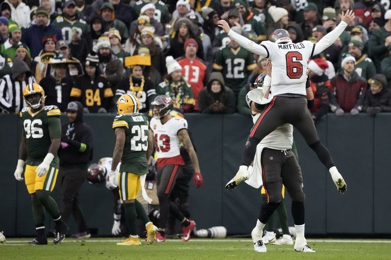 Baker Mayfield (6), quarterback de los Buccaneers de Tampa Bay, celebra con el centro Robert Hainsey después de lanzar un pase de anotación de 52 yardas durante la segunda mitad del juego de la NFL en contra de los Packers de Green Bay, el domingo 17 de diciembre de 2023, en Green Bay, Wisconsin. (AP Foto/Morry Gash)