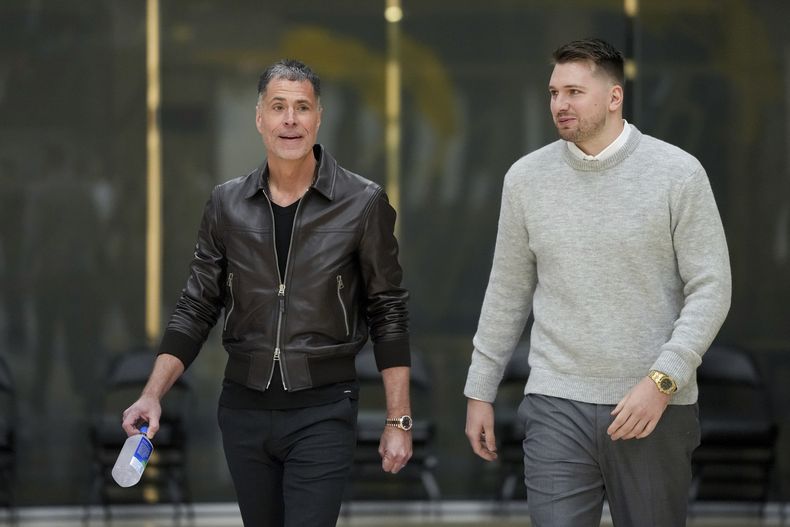 Luka Doncic, de los Lakers de Los Ángeles, a la derecha, camina hacia el podio con el gerente general Rob Pelinka durante una conferencia de prensa de su presentación con el equipo el martes 4 de febrero de 2025 en El Segundo, California (AP Foto/Jae C. Hong)